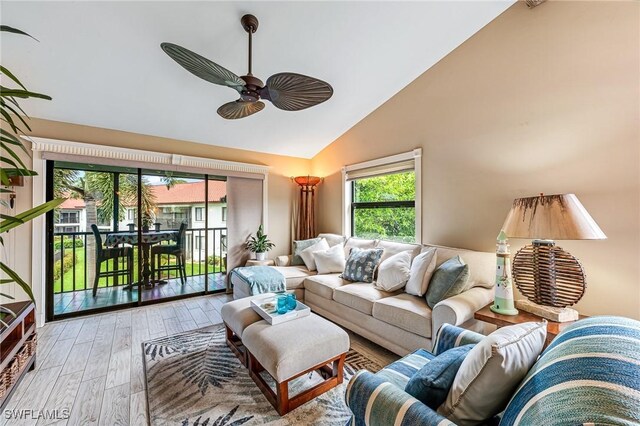 living room with ceiling fan, wood finished floors, and high vaulted ceiling