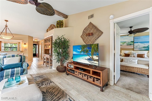 living room featuring ceiling fan, beamed ceiling, and wood finished floors