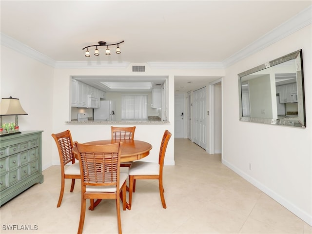 dining room featuring visible vents, crown molding, and baseboards