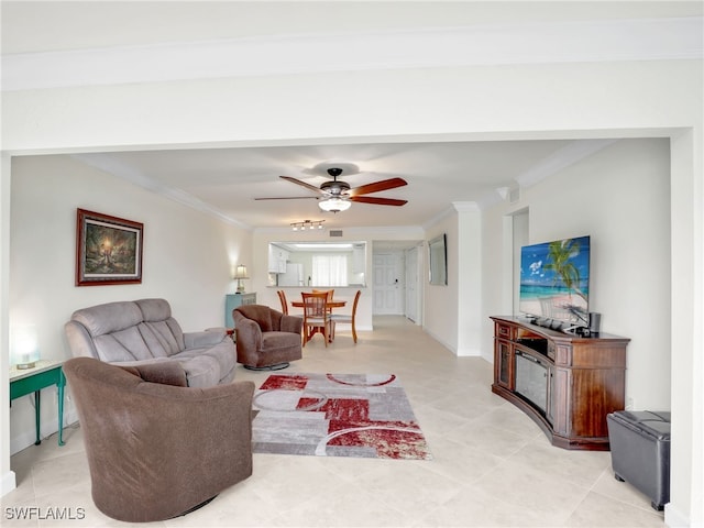 living room with crown molding, baseboards, and ceiling fan