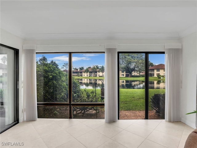 entryway with a healthy amount of sunlight, crown molding, and a water view