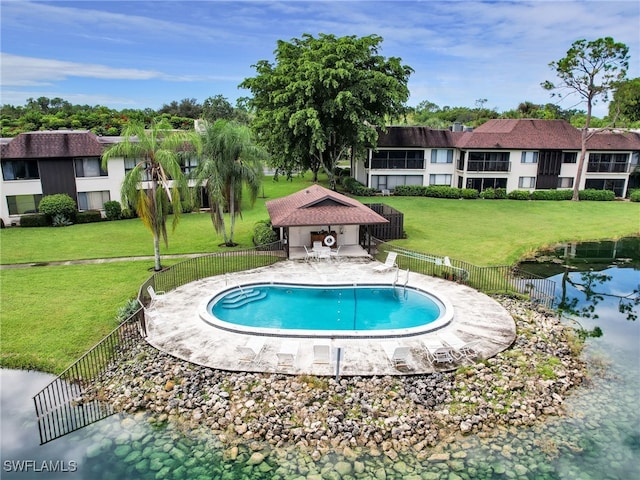 community pool with a yard, a patio, and fence