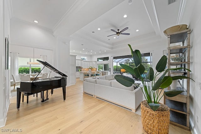 living room with ceiling fan, crown molding, light hardwood / wood-style floors, and a healthy amount of sunlight