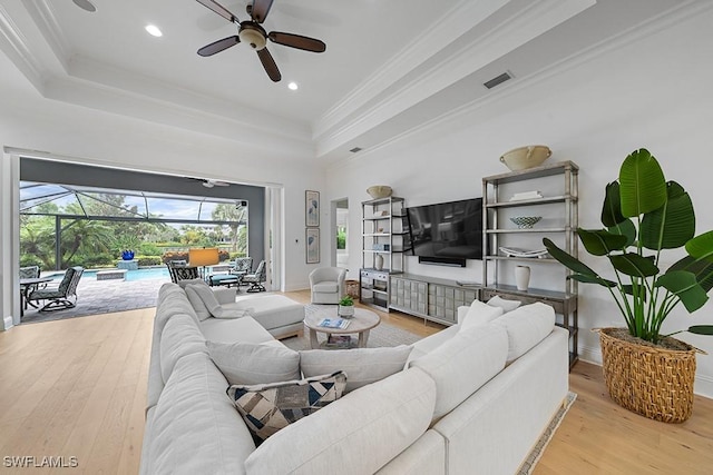 5154 Andros Dr, Naples, FL 34113 - living room with a raised ceiling, a sunroom, a ceiling fan, visible vents, and hardwood / wood-style flooring