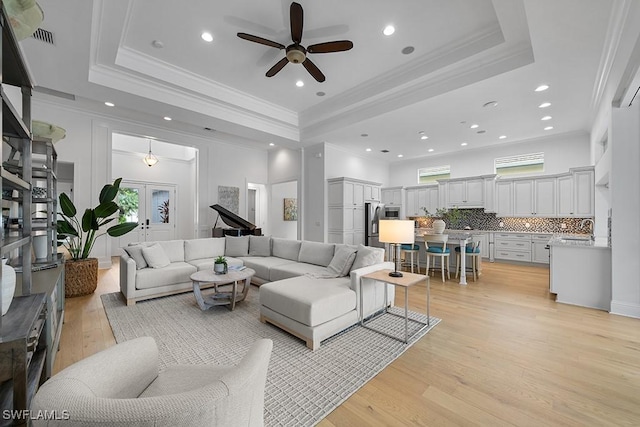 5154 Andros Dr, Naples, FL 34113 - living room with ceiling fan, a healthy amount of sunlight, light wood-style flooring, and a raised ceiling