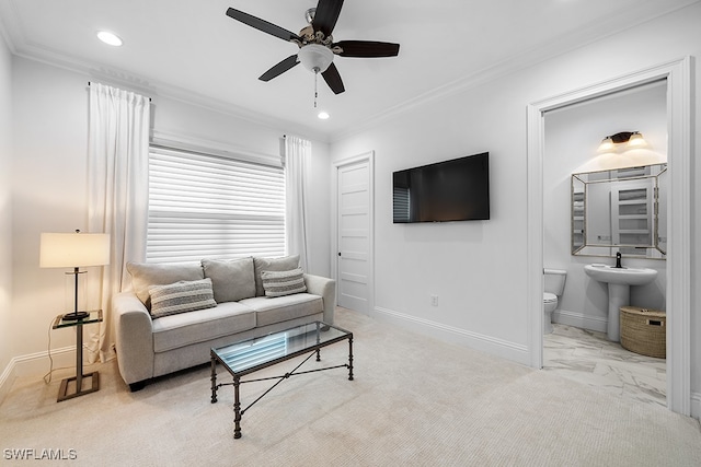 living room featuring ceiling fan, light colored carpet, sink, and crown molding