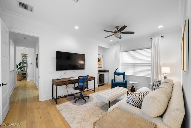 living room with crown molding, beverage cooler, light hardwood / wood-style flooring, and ceiling fan