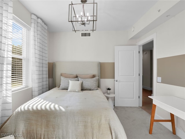 carpeted bedroom with a notable chandelier