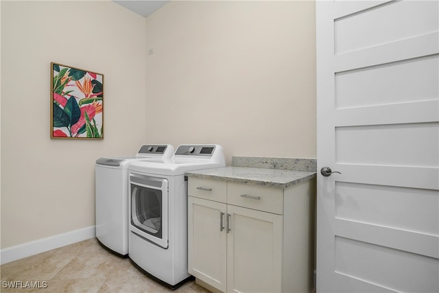 washroom with cabinets, washer and dryer, and light tile patterned flooring