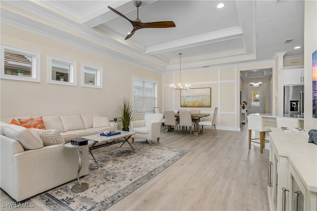 living room with ceiling fan with notable chandelier, light wood-type flooring, and crown molding