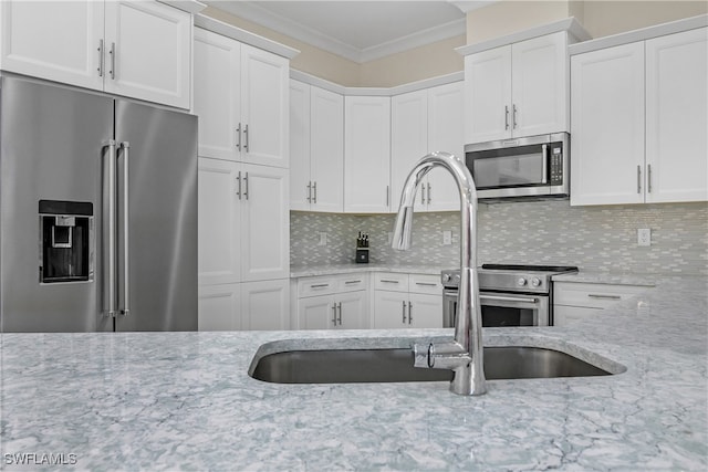 kitchen featuring stainless steel appliances, tasteful backsplash, and white cabinetry