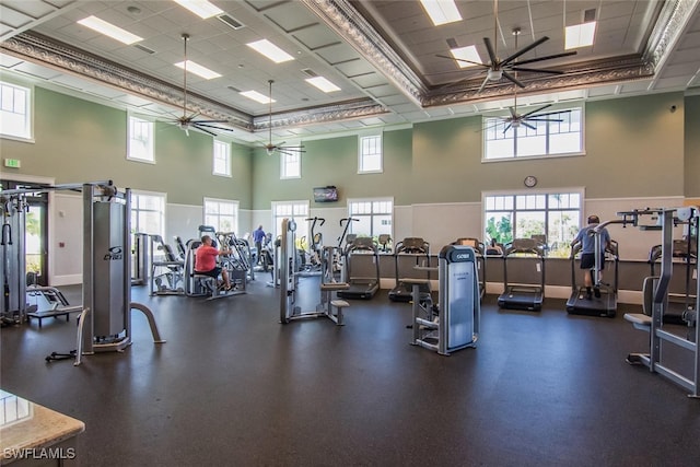 gym featuring a high ceiling, ceiling fan, and crown molding