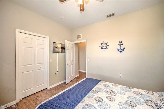 bedroom featuring wood-type flooring, ceiling fan, and a closet