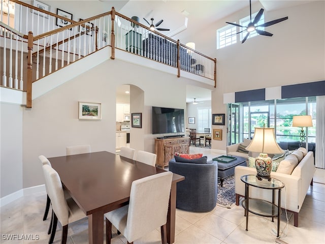 dining area with light tile patterned flooring, ceiling fan, and a high ceiling