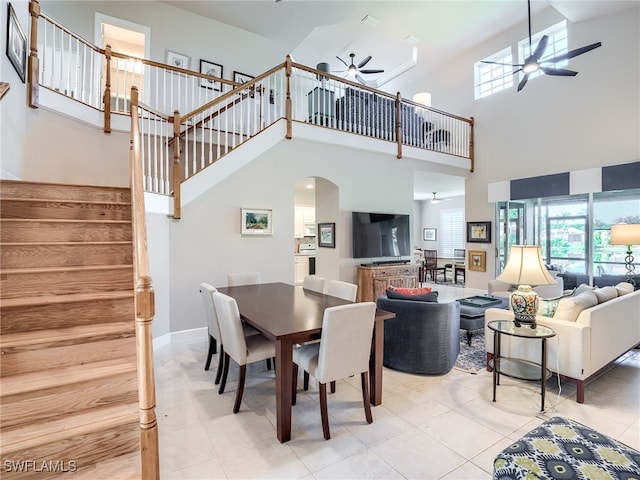 dining area featuring a high ceiling, light tile patterned floors, and ceiling fan