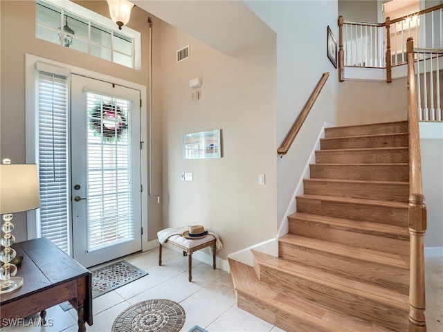 foyer entrance with a high ceiling and light tile patterned flooring