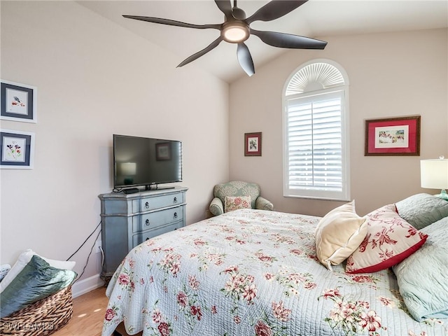 bedroom with hardwood / wood-style floors, vaulted ceiling, and ceiling fan