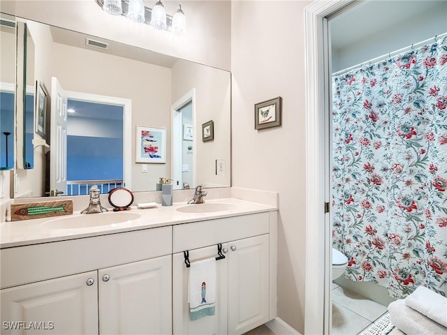 bathroom featuring tile patterned flooring, vanity, toilet, and walk in shower