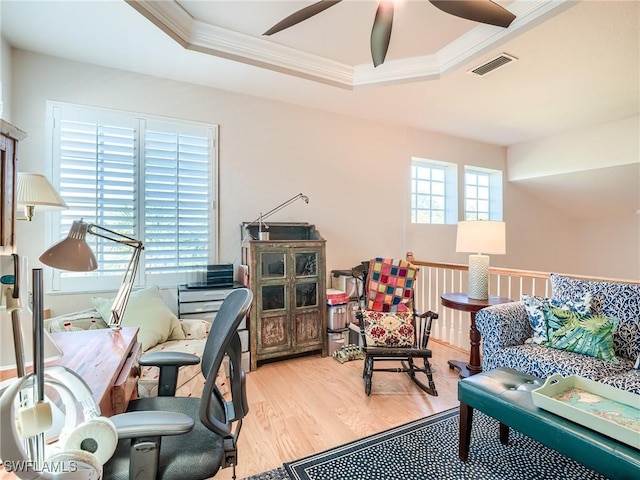 sitting room with a healthy amount of sunlight, ornamental molding, and a raised ceiling