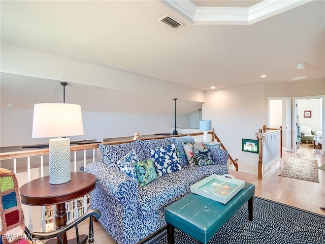 living room featuring crown molding and light hardwood / wood-style floors