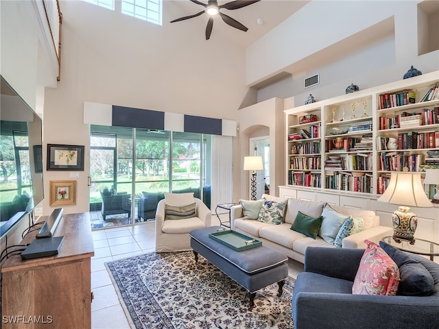 living room featuring a high ceiling, light tile patterned floors, and ceiling fan