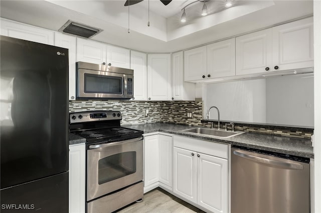 kitchen featuring sink, white cabinets, decorative backsplash, appliances with stainless steel finishes, and ceiling fan