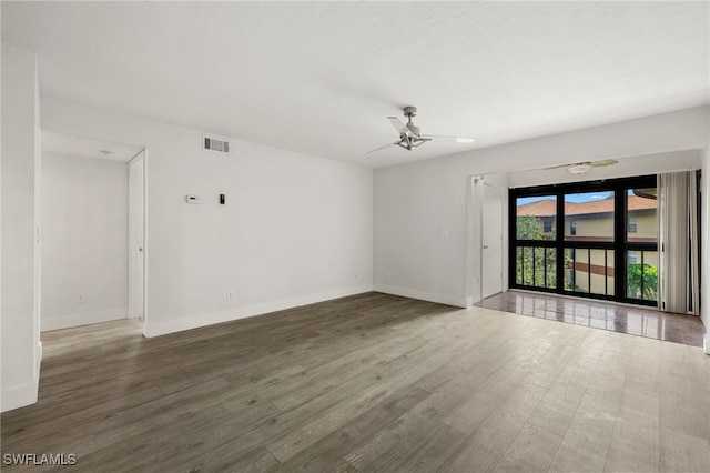 unfurnished room with ceiling fan and dark hardwood / wood-style flooring