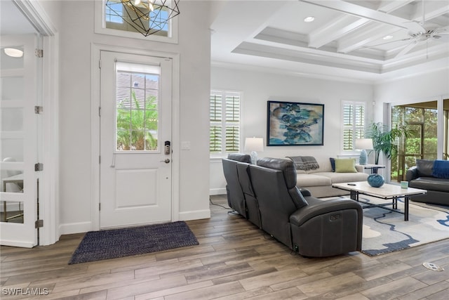 entrance foyer featuring coffered ceiling, plenty of natural light, and light hardwood / wood-style floors