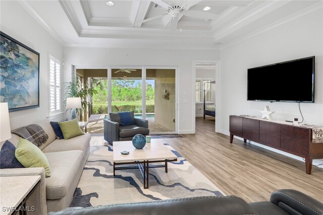 living room with light wood-type flooring, coffered ceiling, ceiling fan, and a wealth of natural light