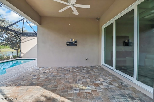 view of pool with ceiling fan, a lanai, and a patio area