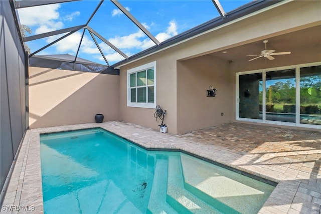 view of swimming pool featuring a lanai, ceiling fan, and a patio area