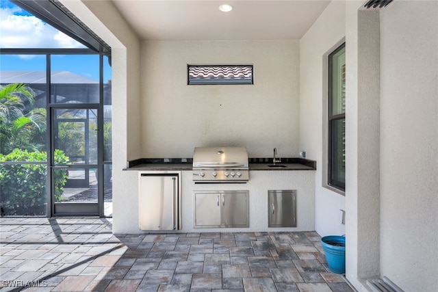 view of patio featuring grilling area, area for grilling, a lanai, and sink