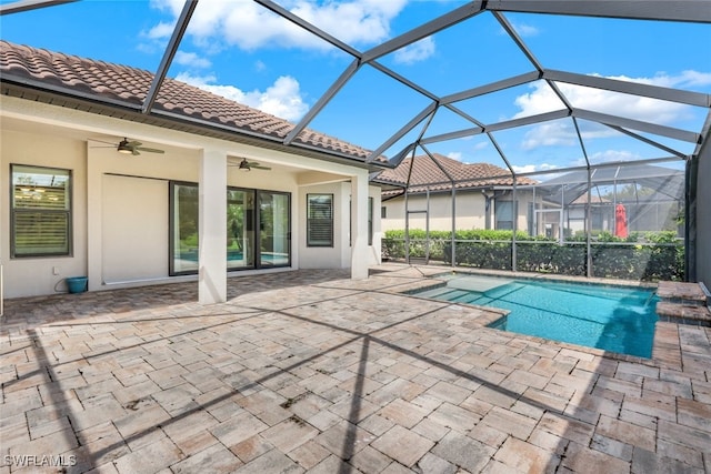 view of swimming pool featuring pool water feature, glass enclosure, ceiling fan, and a patio area