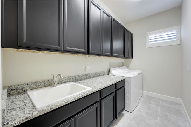 clothes washing area featuring washer and clothes dryer, light tile patterned floors, cabinets, and sink