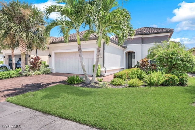 mediterranean / spanish home featuring a front yard and a garage