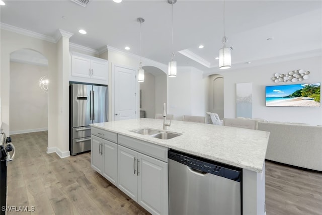 kitchen with white cabinets, stainless steel appliances, light hardwood / wood-style flooring, a kitchen island with sink, and sink