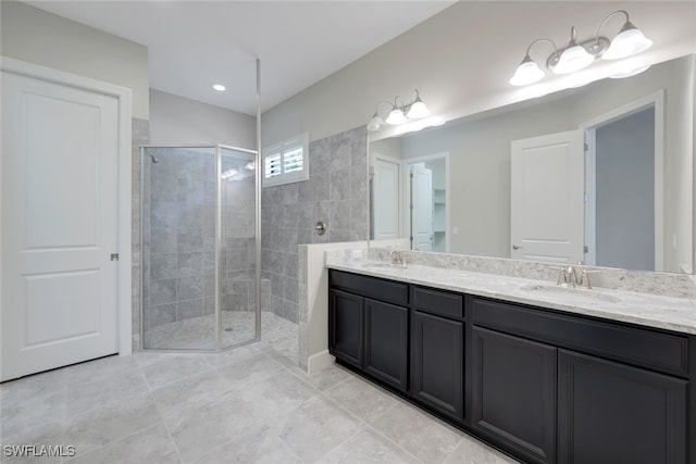 bathroom featuring a tile shower, tile patterned flooring, and vanity