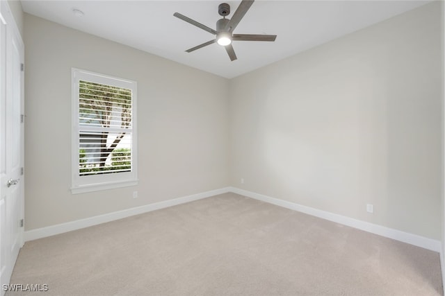 carpeted spare room with ceiling fan