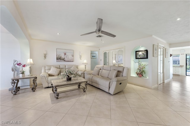 living room featuring ceiling fan, light tile patterned floors, and crown molding