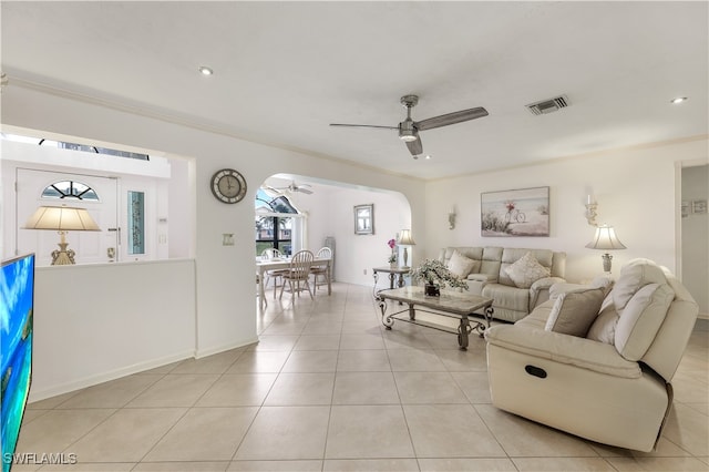 tiled living room featuring crown molding and ceiling fan