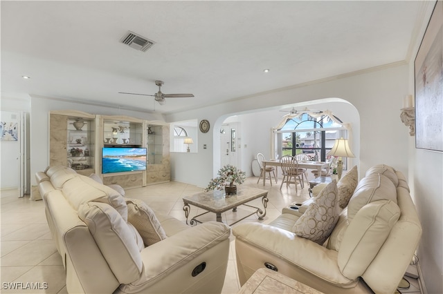 tiled living room with ceiling fan and ornamental molding