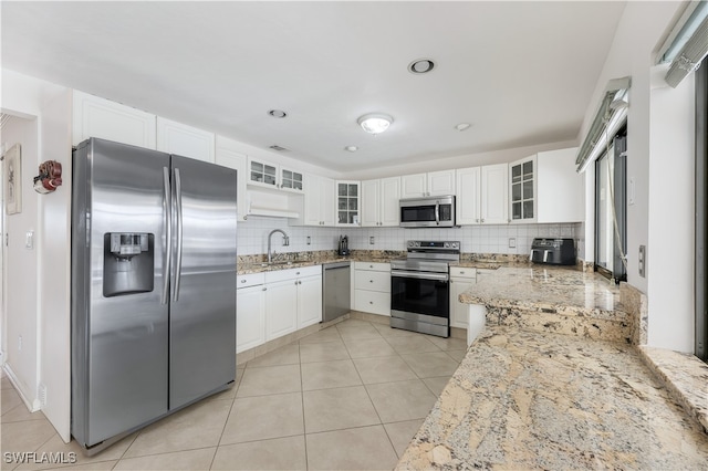 kitchen featuring light stone countertops, appliances with stainless steel finishes, backsplash, and white cabinetry