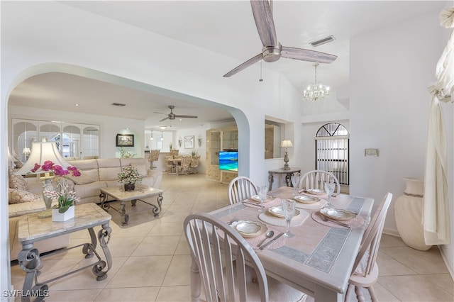 dining space with a healthy amount of sunlight, vaulted ceiling, an inviting chandelier, and light tile patterned floors