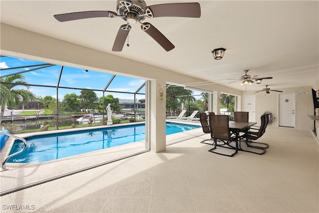 view of pool with ceiling fan, glass enclosure, and a patio area