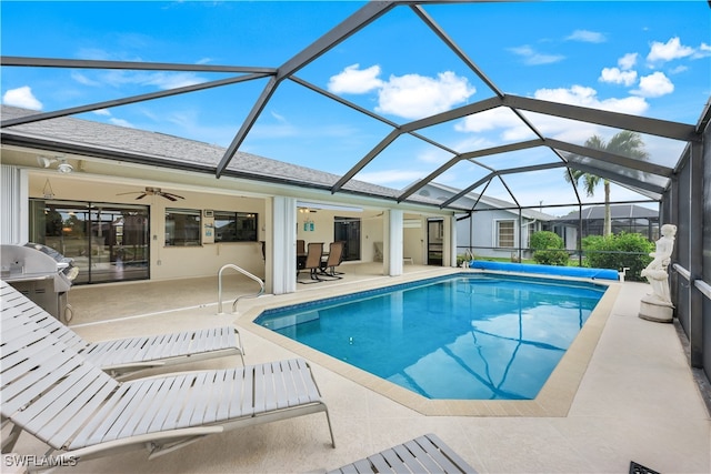 view of swimming pool with glass enclosure, grilling area, ceiling fan, and a patio area