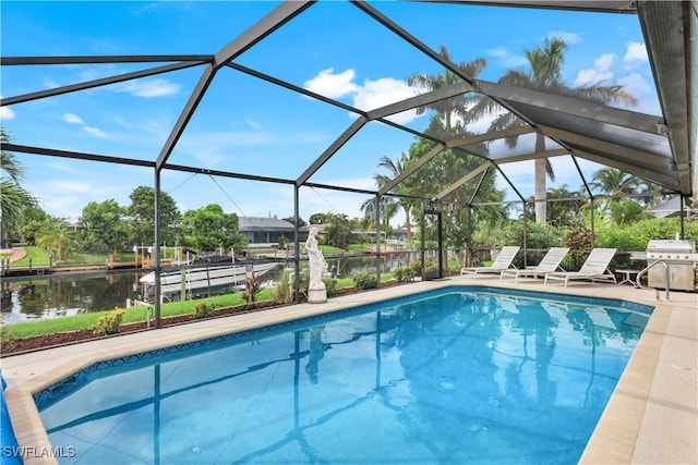 view of swimming pool featuring a lanai, a water view, a grill, and a patio area