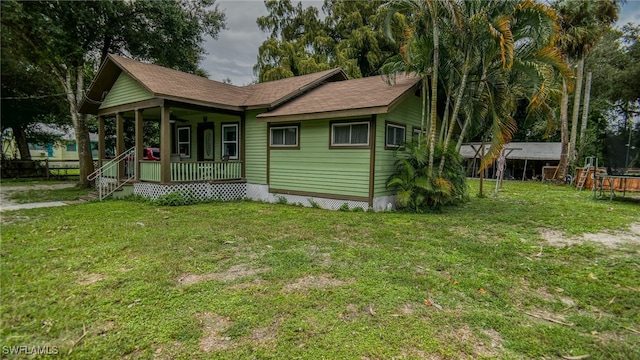 rear view of property with a lawn and covered porch