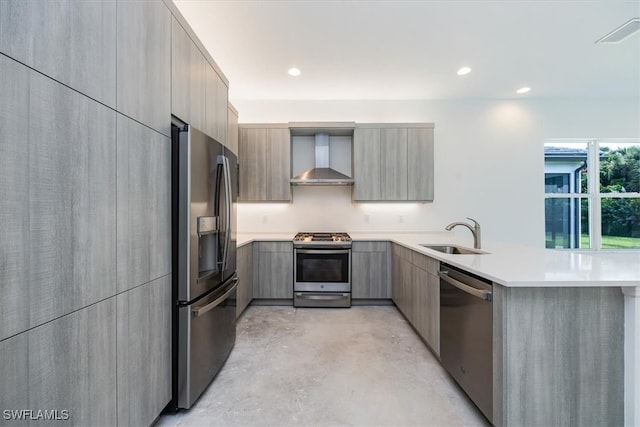 kitchen with wall chimney exhaust hood, appliances with stainless steel finishes, sink, and kitchen peninsula