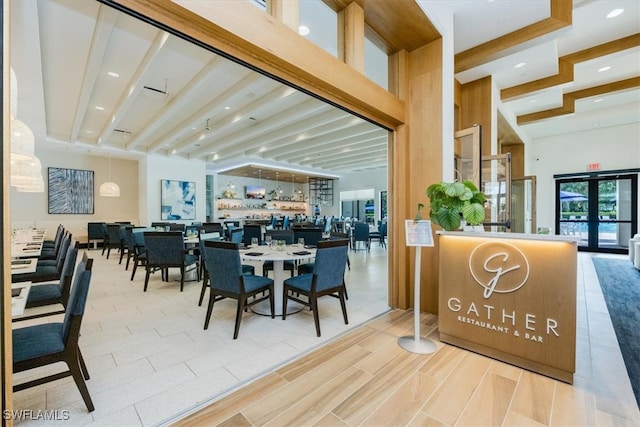 dining area featuring beamed ceiling and french doors