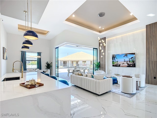 living room with a tray ceiling and sink